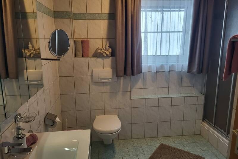 Badezimmer mit Waschbecken, Dusche und WC